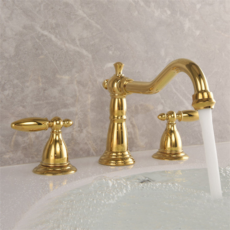 Gold-colored Lumière brass washbasin tap with double levers and 3-hole connection from Ymonde
